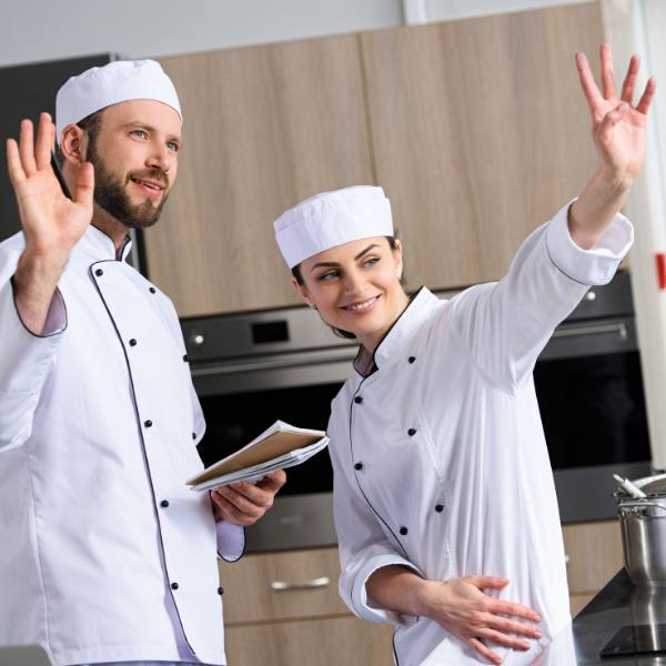 Lady and man chefs waving